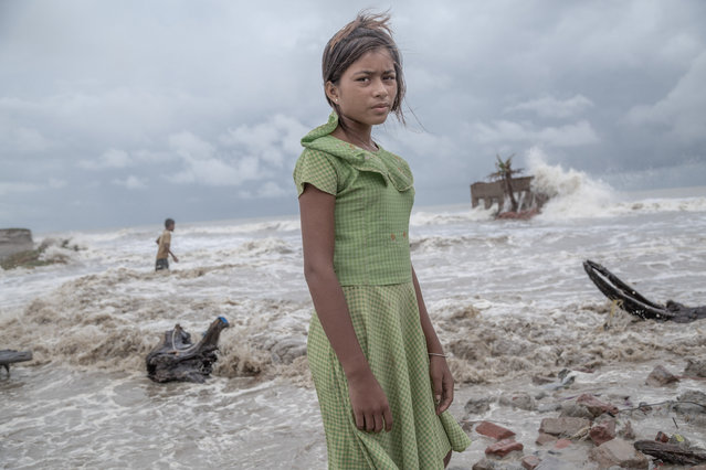 A girl, standing before her tea shop, which is completely ruined by sea water in Frazerganj, Sundarbans, India on August 18, 2020. After Cyclone Aila struck the Sundarbans in 2009, it became clear that frequent cyclonic events will turn the residents of Sundarbans into climate refugees. Within May 5, 2019 – May 25, 2021, Sundarbans faced cyclones- Fani, Bulbul, Amphan & Yaas – each devastating enough to justify the fear of mass displacement. (Photo by Supratim Bhattacharjee/Mangrove Photography Awards)