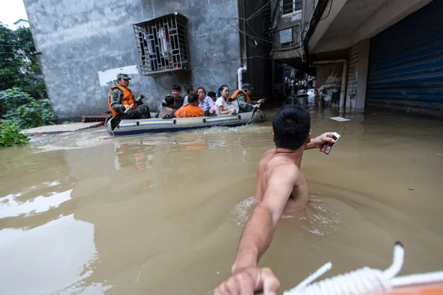Rescuers row as they transfer residents with a boat at a flooded area in Guilin, Guangxi province, China on July 3, 2017. (Photo by Reuters/Stringer)