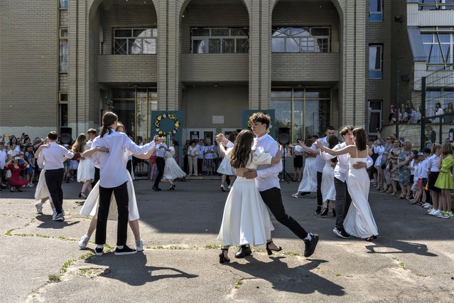 Graduating students perform a dance at School No. 298  during a ceremony marking the last day of school in Kyiv, Ukraine on June 16, 2023. The students were unable to hold a traditional graduation ceremony last year because the school housed Ukrainian soldiers until the end of last summer. (Photo by Brendan Hoffman/The New York Times)