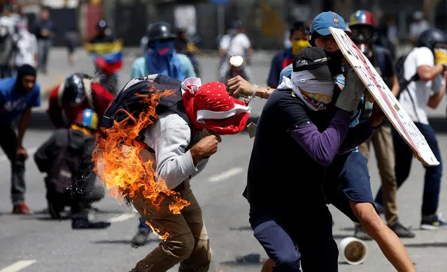 A demonstrator gets himself on fire after he tried to hurl a molotov cocktail during a protest against Venezuela's President Nicolas Maduro's government in Caracas, Venezuela July 10, 201. (Photo by Andres Martinez Casares/Reuters)