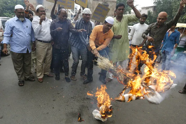 Indian Muslims burn an effigy representing Pakistan and terrorism during a protest against the terrorist attack on pilgrims, in Ahmadabad, India, Tuesday, July 11, 2017. Gunmen sprayed bullets on a passenger bus bringing Hindu pilgrims back from a cave shrine in Indian-controlled Kashmir on Monday, killing at least seven of them, including five women, and wounding 14 others, police said. (Photo by Ajit Solanki/AP Photo)