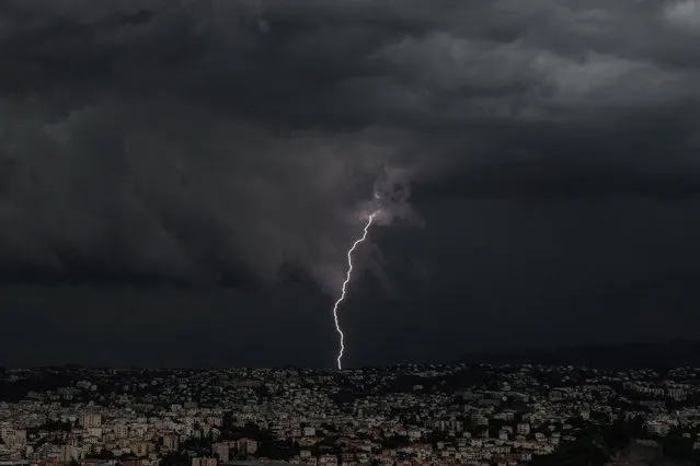 Lightning strikes over the French Riviera city of Nice on September 26, 2021. (Photo by Valery Hache/AFP Photo)