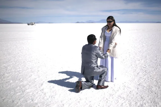 A couple poses during a mass wedding for 34 couples at Uyuni Salt Flats on May 20, 2022 in Uyuni, Bolivia. The civil registration organized an open opportunity for citizens from all over Bolivia to get married in the first mass wedding at the Uyuni salt flats. (Photo by Gaston Brito Miserocchi/Getty Images)