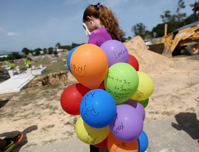 A relative of Xavier Emmanuel Serrano Rosado, one of the victims of the shooting at the Pulse night club in Orlando, reacts while carrying balloons inscribed to him during his funeral in his hometown of Ponce, Puerto Rico, June 24, 2016. (Photo by Alvin Baez/Reuters)