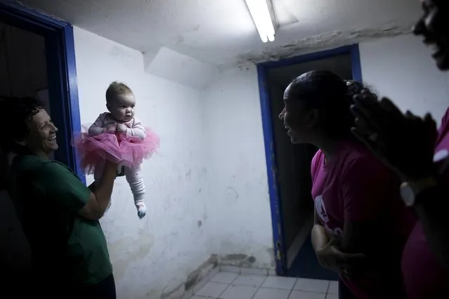 Silvana (R) holds a three-month-old baby inside their house before her sister takes ballet lesson at the New Dreams dance studio, in the Luz neighborhood known to locals as Cracolandia (Crackland) in Sao Paulo, Brazil, August 12, 2015. (Photo by Nacho Doce/Reuters)