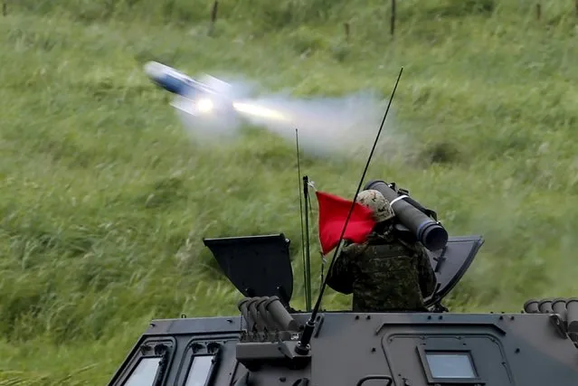 A Japanese Ground Self-Defense Force soldier on an armoured vehicle fires a guided anti-tank missile during an annual training session, which is based on a scenario to defend or retake islands in Japanese territory, near Mount Fuji at Higashifuji training field in Gotemba, west of Tokyo, August 18, 2015. (Photo by Yuya Shino/Reuters)