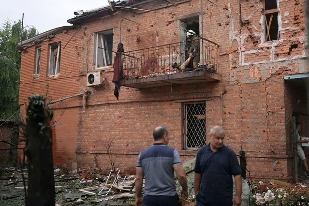Rescuers extract a body from a residential building damaged by a Russian military strike, as Russia's invasion of Ukraine continues, in Kharkiv, Ukraine on July 11, 2022. (Photo by Nacho Doce/Reuters)