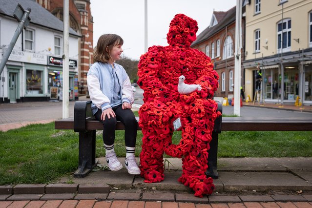 Grace Smith, six, sits next to an installation made of knitted poppies at a war memorial in Chesham, Buckinghamshire, UK on November 2, 2024. She thought the piece was “really cool”. (Photo by Joshua Bratt for the Times)