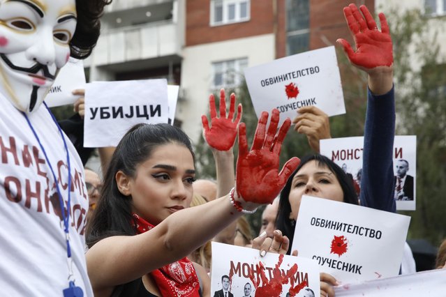 Protestors with red painted hands chant “Murderers” in front of the Government building in Skopje, North Macedonia, on Monday, September 4. 2023. Thousands have gathered late on Monday in front of the government in North Macedonia's capital Skopje to protest on scandal that broke after media reported that employees in the state running Clinic of Oncology allegedly were selling on a black market a million of dollars' worth clinic supply of drugs needed for cancer treatment. (Photo by Boris Grdanoski/AP Photo)