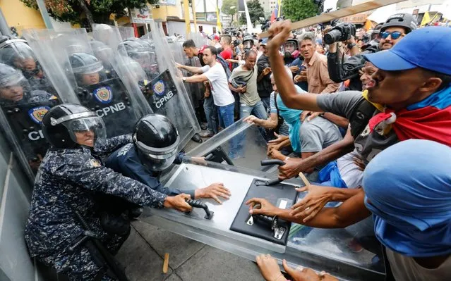 Opposition protesters clash with police blocking their march in Caracas, Venezuela, Tuesday, March 10, 2020. U.S.-backed Venezuelan political leader Juan Guaido is leading a march aimed at retaking the National Assembly legislative building, which opposition lawmakers have been blocked from entering. (Photo by Ariana Cubillos/AP Photo)