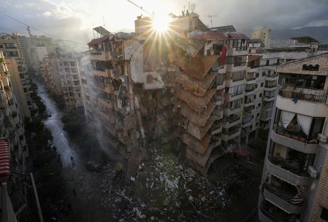 People walk past damaged buildings, in the aftermath of Israeli strikes on Beirut's southern suburbs, in  Lebanon on November 25, 2024. (Photo by Mohammed Yassin/Reuters)