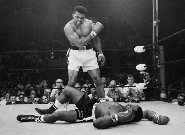 In this May 25, 1965, file photo, heavyweight champion Muhammad Ali stands over fallen challenger Sonny Liston, shouting and gesturing shortly after dropping Liston with a short hard right to the jaw in the first round of their title fight in Lewiston, Maine. The bout produced one of the strangest finishes in boxing history as well as one of sports' most iconic moments. (Photo by John Rooney/AP Photo)