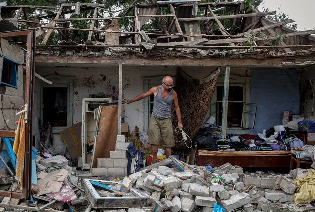 A local resident collects belongings from his destroyed house after a night missile strike in the town of Kramatorsk, in Donetsk region, on August 16, 2022, amid the Russian military invasion of Ukraine. (Photo by Anatolii Stepanov/AFP Photo)