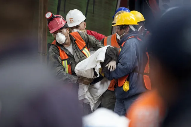 Rescue workers carry a body recovered from a building felled by a 7.1 magnitude earthquake, in the Ciudad Jardin neighborhood of Mexico City, Thursday, September 21, 2017. (Photo by Moises Castillo/AP Photo)