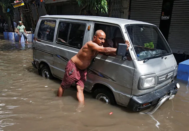 A man pushes his van through a flooded street after heavy rains in Kolkata, India, August 11, 2016. (Photo by Rupak De Chowdhuri/Reuters)