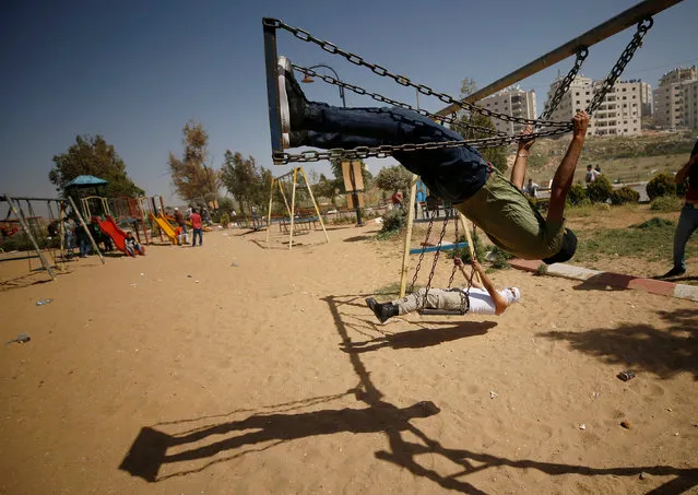 Palestinian protesters swing as they rest at a park during clashes with Israeli troops at a protest in support of Palestinian prisoners on hunger strike in Israeli jails, near the Jewish settlement of Beit El, near the West Bank city of Ramallah May 11, 2017. (Photo by Mohamad Torokman/Reuters)