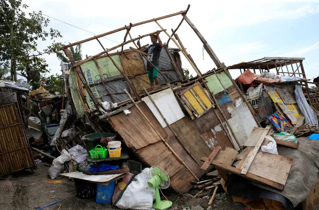 A resident fixes his damaged shanty after a tornado and torrential downpour brought on by monsoon rains battered a residential area in Baseco, Tondo city, metro Manila, Philippines August 15, 2016. (Photo by Romeo Ranoco/Reuters)