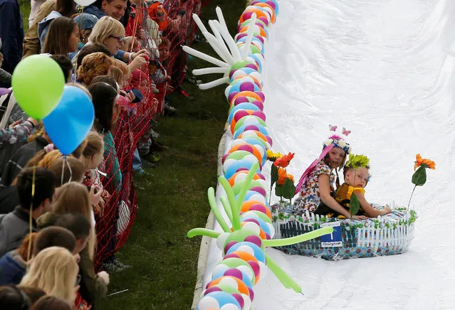 Participants slide down along a chute to cross a pool of water and foam during the “Letniy Gornoluzhnik” (Summer mountain puddle rider) festival at the Bobroviy Log Fun Park near the Siberian city of Krasnoyarsk, Russia, August 21, 2016. (Photo by Ilya Naymushin/Reuters)