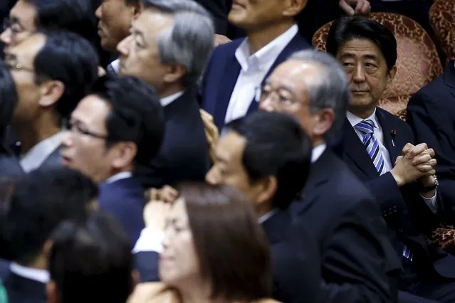 Japan's Prime Minister Shinzo Abe (R) looks at lawmakers crowding around Yoshitada Konoike, chairman of the upper house special committee on security, during a vote at an upper house special committee session on security-related legislation at the parliament in Tokyo, Japan, September 17, 2015. (Photo by Toru Hanai/Reuters)