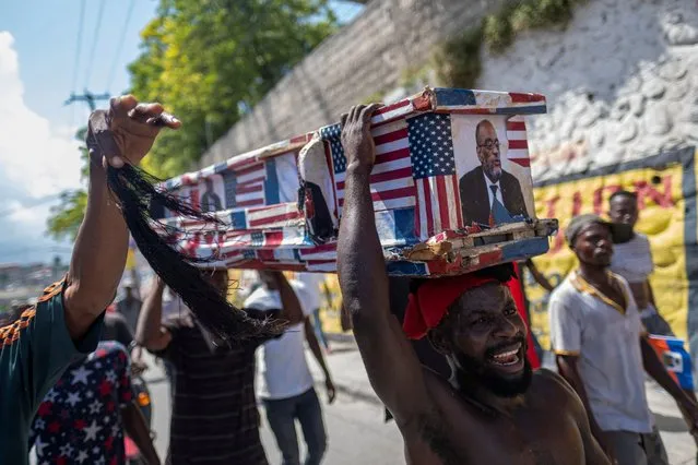 People carry a mock coffin with a photo of Haiti’s Prime Minister Ariel Henry and the U.S. and Canada flags attached during a protest demanding his resignation after weeks of shortages in Port-au-Prince, Haiti on October 17, 2022. (Photo by Ricardo Arduengo/Reuters)