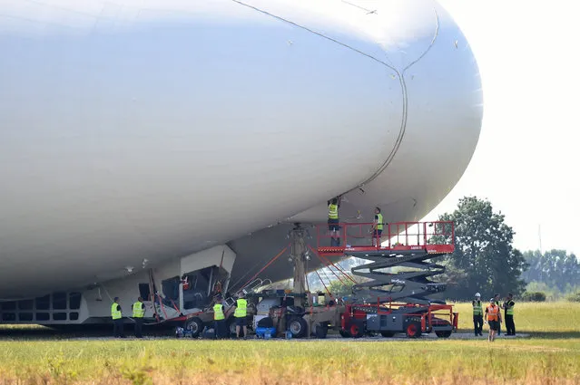 The Airlander 10, is examined as it sits on the ground after a rough landing  at Cardington airfield England  following its second test flight on Wednesday August 24, 2016. The developer of the world's largest aircraft says the blimp-shaped airship “sustained damage” after it made a bumpy landing on its second test flight . Hybrid Air Vehicles says it is trying to figure out what caused the rough landing of the 302-foot (92-meter) Airlander 10 during its flight Wednesday in Bedfordshire, north of London. (Photo by Dominic Lipinski/PA Wire via AP Photo)