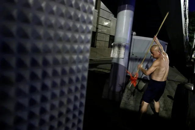 A man uses a spear as he practices martial art in a street at night in Beijing, China, August 27, 2016. (Photo by Thomas Peter/Reuters)