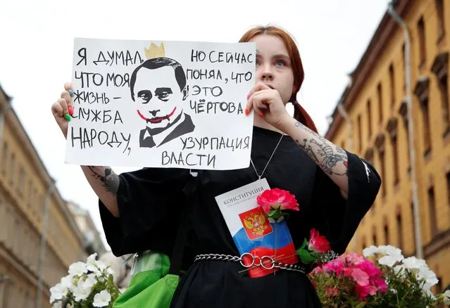A participant holds a placard during a protest against amendments to Russia's Constitution and the results of a nationwide vote on constitutional reforms, in Saint Petersburg, Russia on July 15, 2020. The placard reads: “I thought my life is about serving the people, but now I realize it's a damn usurpation of power”. (Photo by Anton Vaganov/Reuters)