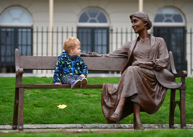 Ludovic Woolf, great, great nephew of British author Virginia Woolf, sits next to a new bronze statue of Woolf, unveiled in Richmond, London, Britain on November 16, 2022. (Photo by Toby Melville/Reuters)