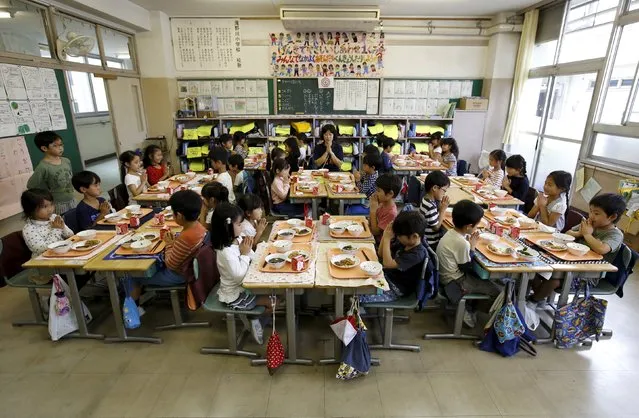 First grade students and their teacher Teruko Takakusaki pose for a photo during lunch at Takinogawa Elementary School in Tokyo, Japan, September 18, 2015. (Photo by Toru Hanai/Reuters)