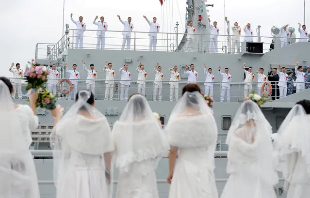 Navy personnel of People's Liberation Army (PLA) wave at their brides during a mass wedding at a military base in Zhoushan, Zhejiang province, China December 29, 2017. (Photo by Reuters/China Stringer Network)