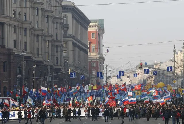 People walk with flags and posters as they attend a demonstration on National Unity Day in Moscow November 4, 2014. (Photo by Sergei Karpukhin/Reuters)