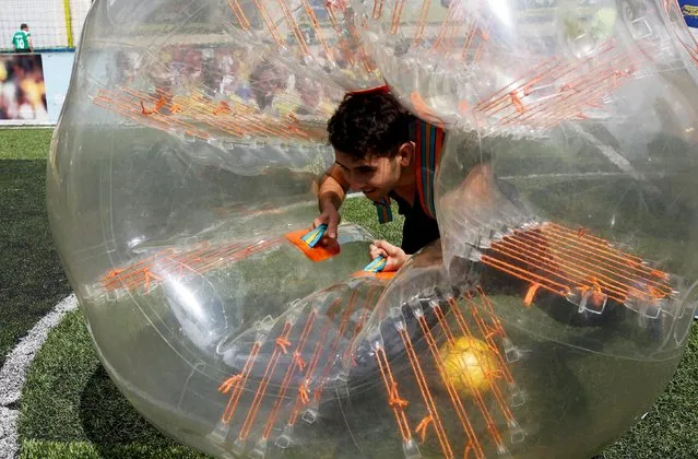 A man takes part in a game of 'bubble bump soccer' during an exhibition tournament in Medellin, Colombia, October 10, 2015. (Photo by Fredy Builes/Reuters)