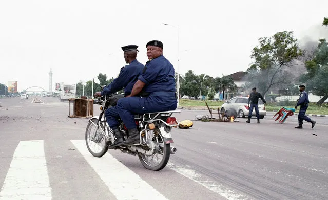 Congolese police move to clear a barricade mounted at an intersection near Echangeur de Limete as opposition activists marched to press President Joseph Kabila to step down in the Democratic Republic of Congo's capital Kinshasa, September 19, 2016. (Photo by Reuters/Stringer)