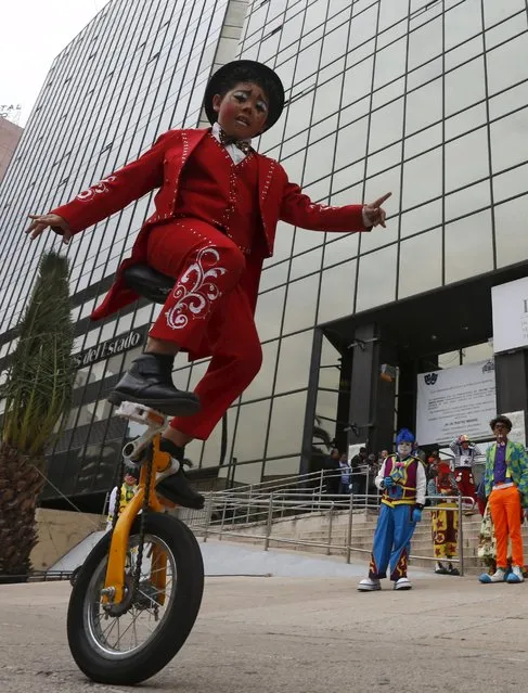 A clown rides his unicycle next to the Monument to the Revolution as he takes part in the Latin American Clown Convention in Mexico City, Mexico, October 21, 2015. (Photo by Henry Romero/Reuters)