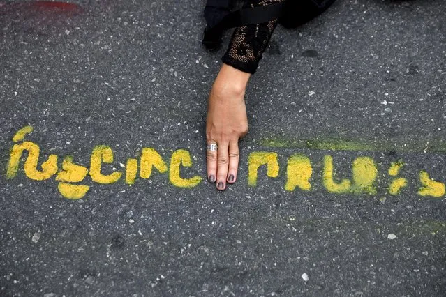 A person flashes the three-fingers salute in the middle of a message reading “Long live the people” painted on the pavement during a Thai anti-government mass protest, on the 47th anniversary of the 1973 student uprising, near the Democracy monument, in Bangkok, Thailand on October 14, 2020. (Photo by Soe Zeya Tun/Reuters)