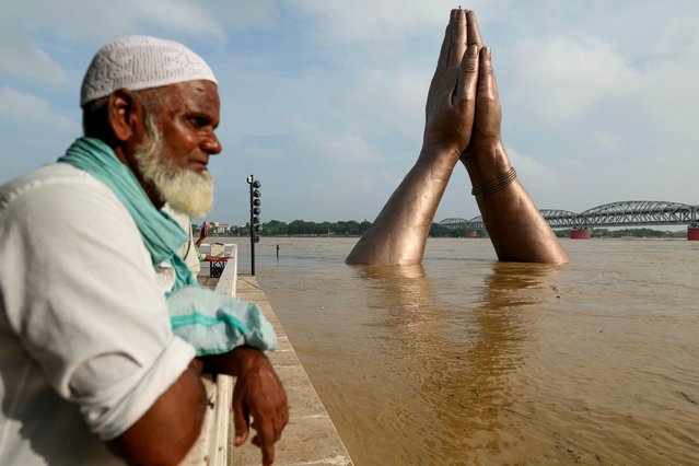 A man stands at the flooded Namo Ghat along the river Ganges, following monsoon rains in Varanasi on August 1, 2025. (Photo by Niharika Kulkarni/AFP Photo)