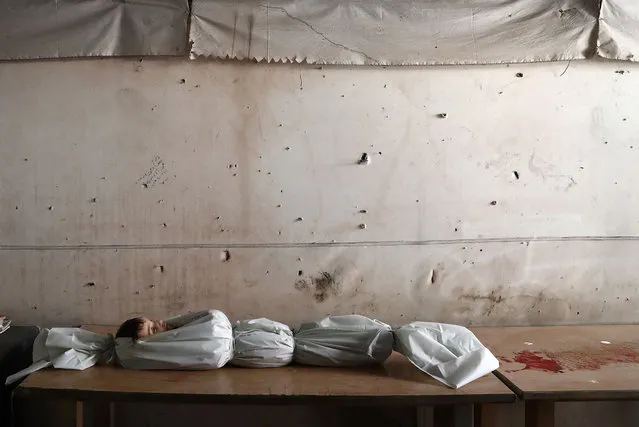 The body of a Syrian child lies on a table at a morgue on October 5, 2016, following reported air strikes on the rebel-held town of Douma, on the eastern outskirts of the capital Damascus. (Photo by Abd Doumany/AFP Photo)