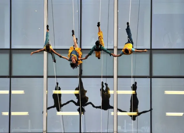 Members of the Bandaloop dance troupe of the U.S. participate in a performance while hanging by ropes outside an office building in Shanghai, China, October 23, 2015. (Photo by Reuters/Stringer)