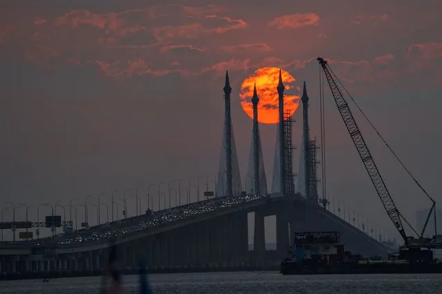 The sun rises as vehicles cross over the Penang Bridge on Penang island, northern Malaysia, Wednesday, March 8, 2023. (Photo by Vincent Thian/AP Photo)