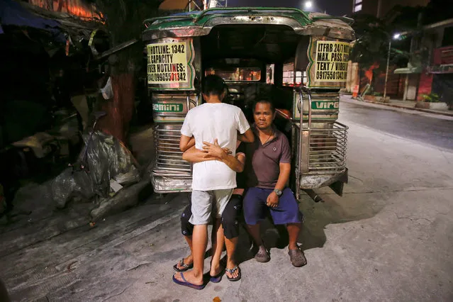 A woman hugs her grandson after telling him that his father was killed in a police operation shortly before in Manila, Philippines early October 18, 2016. The boy's uncle, suffering from a stroke, sits next to them. (Photo by Damir Sagolj/Reuters)