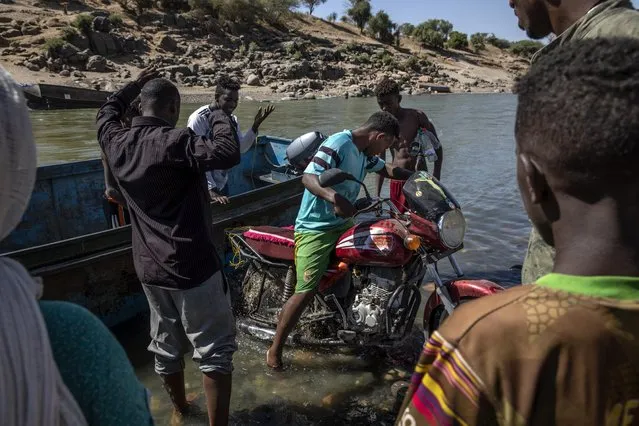 Tigray refugees who fled the conflict in the Ethiopia's Tigray arrive with their motorcycle on the banks of the Tekeze River on the Sudan-Ethiopia border, in Hamdayet, eastern Sudan, Tuesday, December 1, 2020. (Photo by Nariman El-Mofty/AP Photo)