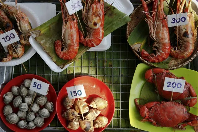 Vendors offer seafood from their small boats as tourists visit the Amphawa floating market at Samut Songkhram province in this March 16, 2013 file photo. (Photo by Damir Sagolj/Reuters)