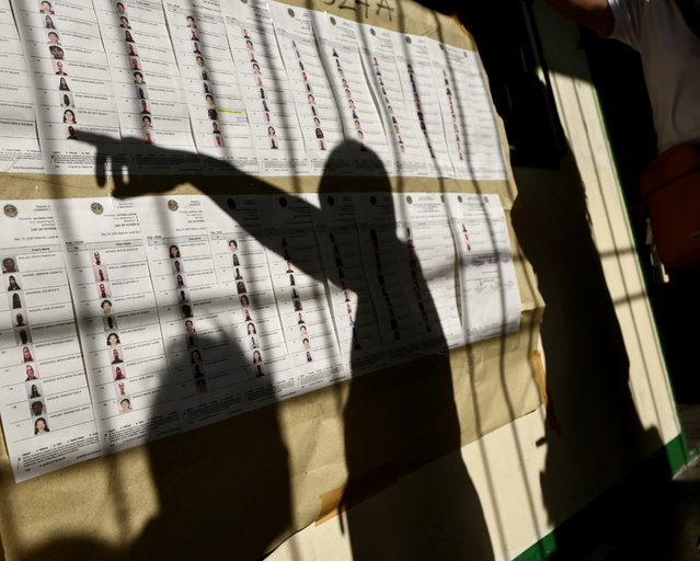 Filipinos look for their names on charts to cast their election ballots at a school used as a polling station in  Muntinlupa city, Metro Manila, Philippines, 12 May 2025. Filipinos trooped to polling stations to cast their votes for the 12 May national and local mid-term elections, with approximately 18,000 government positions, ranging from senators to local village officers, expected to be filled. (Photo by Francis R. Malasig/EPA)