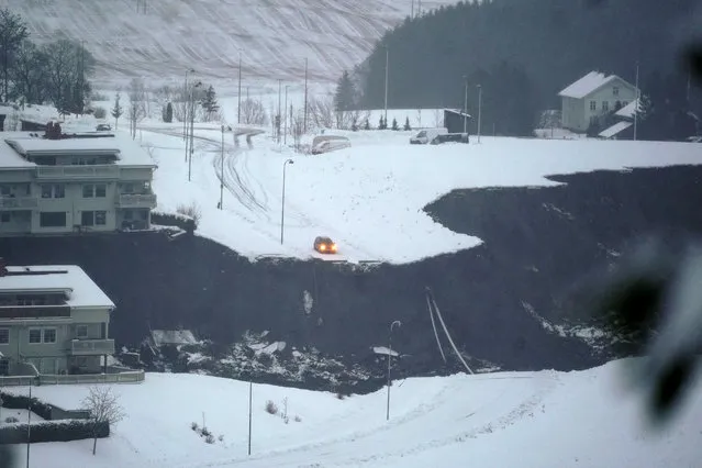 A car is stopped at the edge of a cliff after a landslide occurred in a residential area in Ask, near Oslo, Wednesday, December 30, 2020. Several houses have been destroyed, up to 200 people have been evacuated and nine injured in Norway in a landslide at a residential area near the capital Oslo. Norwegian police were alarmed around 4 am Wednesday that a landslide had occured in the village of Ask in the municipality of Gjerdrum, some thirty kilometers (12 miles) north of Oslo.  (Photo by Fredrik Hagen/NTB via AP Photo)
