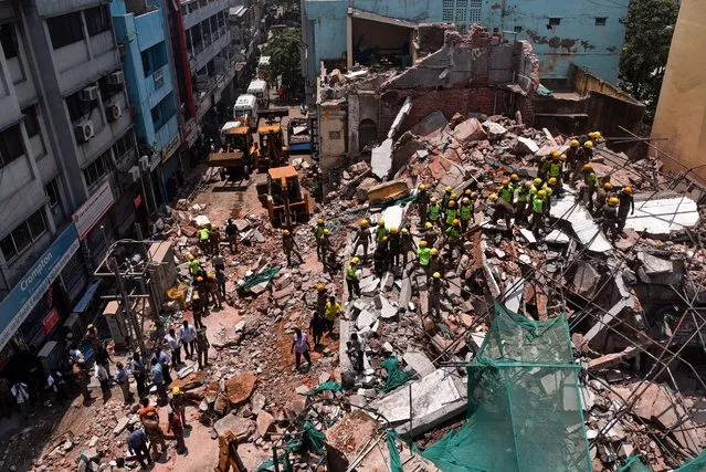 Tamilnadu Fire And Rescue Services personnel carry out a rescue operation after a four-story under-renovation building collapsed, in Chennai, India, 19 April 2023. An old four-story under-renovation building collapsed in Chennai's Armenian street on Wednesday morning, 19 April. Two persons were injured in the building collapse and were shifted to a government hospital. Rescue operations are underway by the Fire and Rescue Service personnel as workers who were inside the building feared being trapped underneath the debris. (Photo by Idrees Mohammed/EPA)