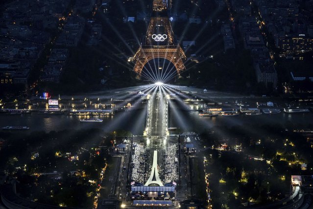 The Eiffel Tower and the Olympics rings are lit up during the opening ceremony for the 2024 Summer Olympics in Paris, France, Friday, July 26, 2024. (Photo by Lionel Bonaventure/Pool Photo via AP Photo)