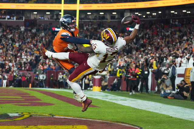Washington Commanders wide receiver Treylon Burks (13) catches a touchdown pass as Denver Broncos cornerback Riley Moss, left, defends during the second half of an NFL football game Sunday, November 30, 2025, in Landover, Md. (Photo by Stephanie Scarbrough/AP Photo)