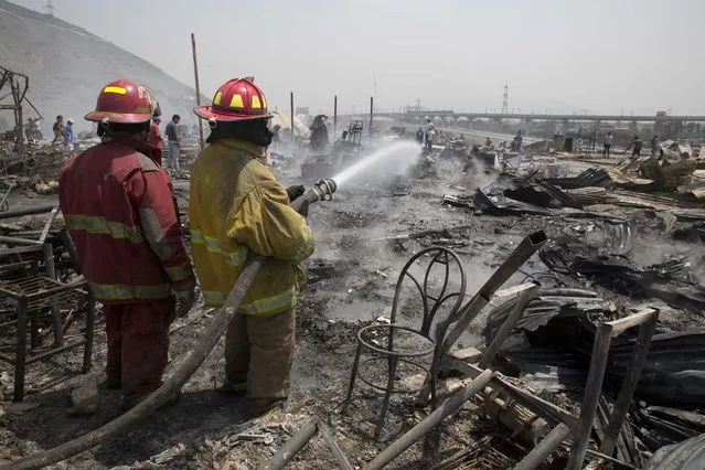 Firefighters work to control an early morning fire that destroyed hundreds of home in the shantytown known as Cantagallo, in Lima, Peru, Friday, November 4, 2016. (Photo by Martin Mejia/AP Photo)