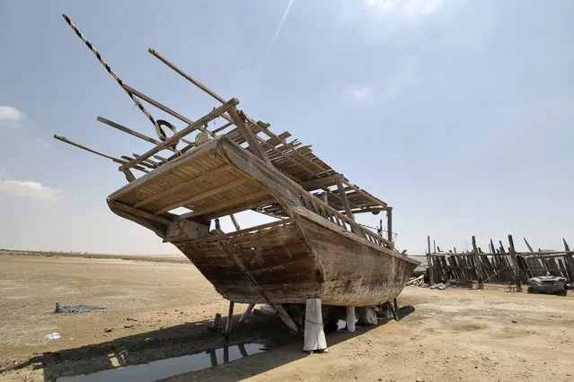 A traditional wooden ship (lenj) is laid ashore for restoration,  in Iran's touristic Qeshm island in the Gulf, on April 29, 2023. (Photo by Atta Kenare/AFP Photo)