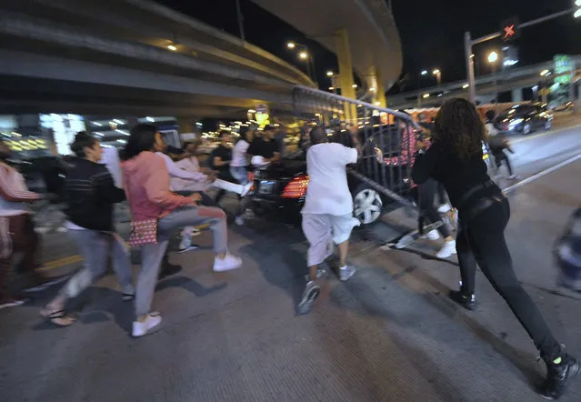 In this Friday, June 22, 2018 photo, a car runs aggressively through a crowd of protesters on the north side on Tony Dorsett Way at West General Robinson Street in Pittsburgh. Protesters upset that some were nearly injured by the vehicle pursued it throwing water bottles and a heavy metal traffic barrier. The protest was in response to the fatal police shooting of 17-year-old Antwon Rose Jr. on Tuesday, who was shot fleeing a traffic stop in Pittsburgh. (Photo by Andrew Stein/Pittsburgh Post-Gazette via AP Photo)